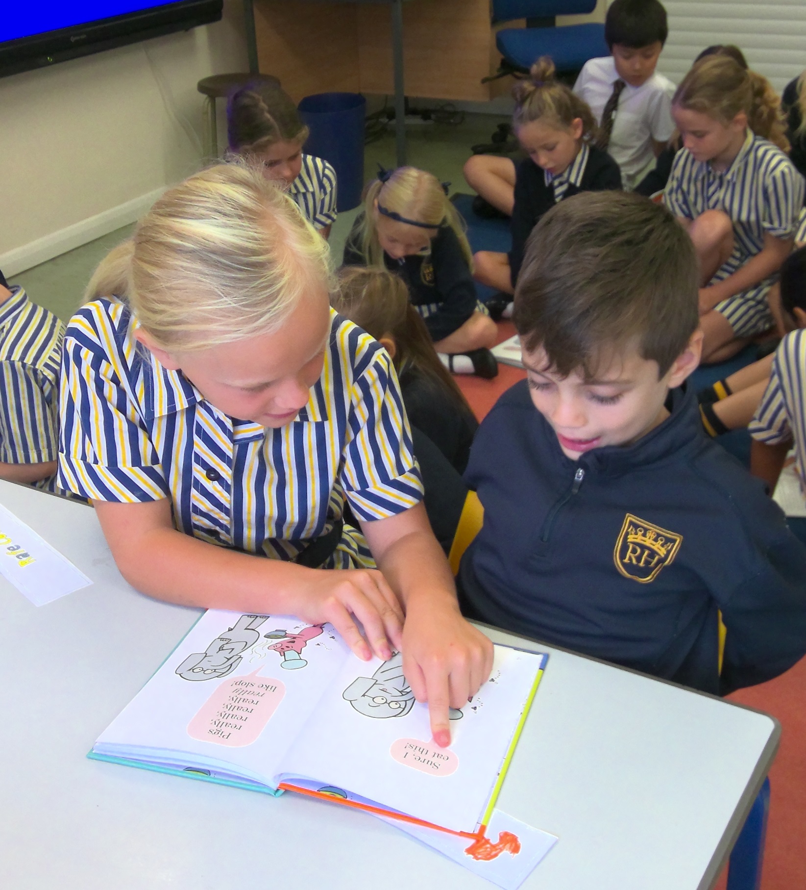 Year 5 Pupil reading to a Year 2 Pupil